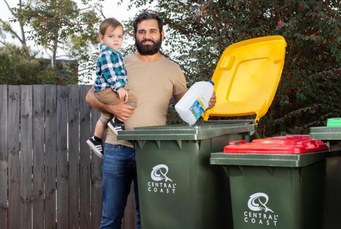 Man with child using recycling
