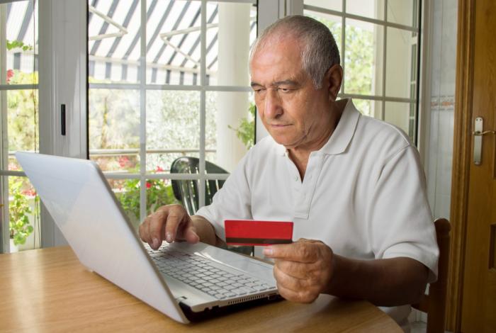 Man at home entering credit card details into a laptop