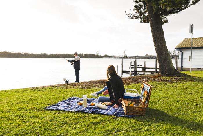 Photo of people having a lakeside picnic. 