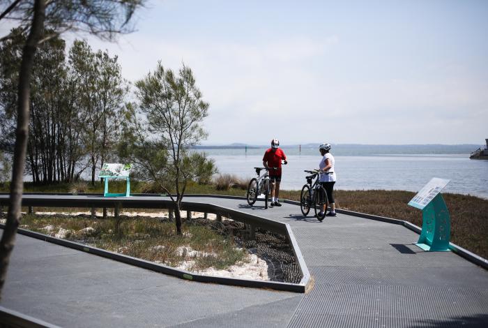 Photo of two cyclists in front of Tuggerah Lake